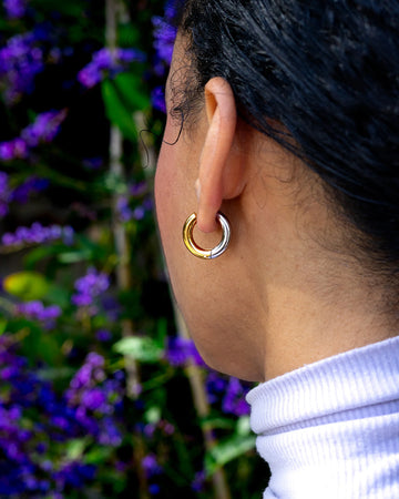model wearing two-toned gold and silver hoop earrings