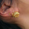 model wearing gold seashell huggie earrings