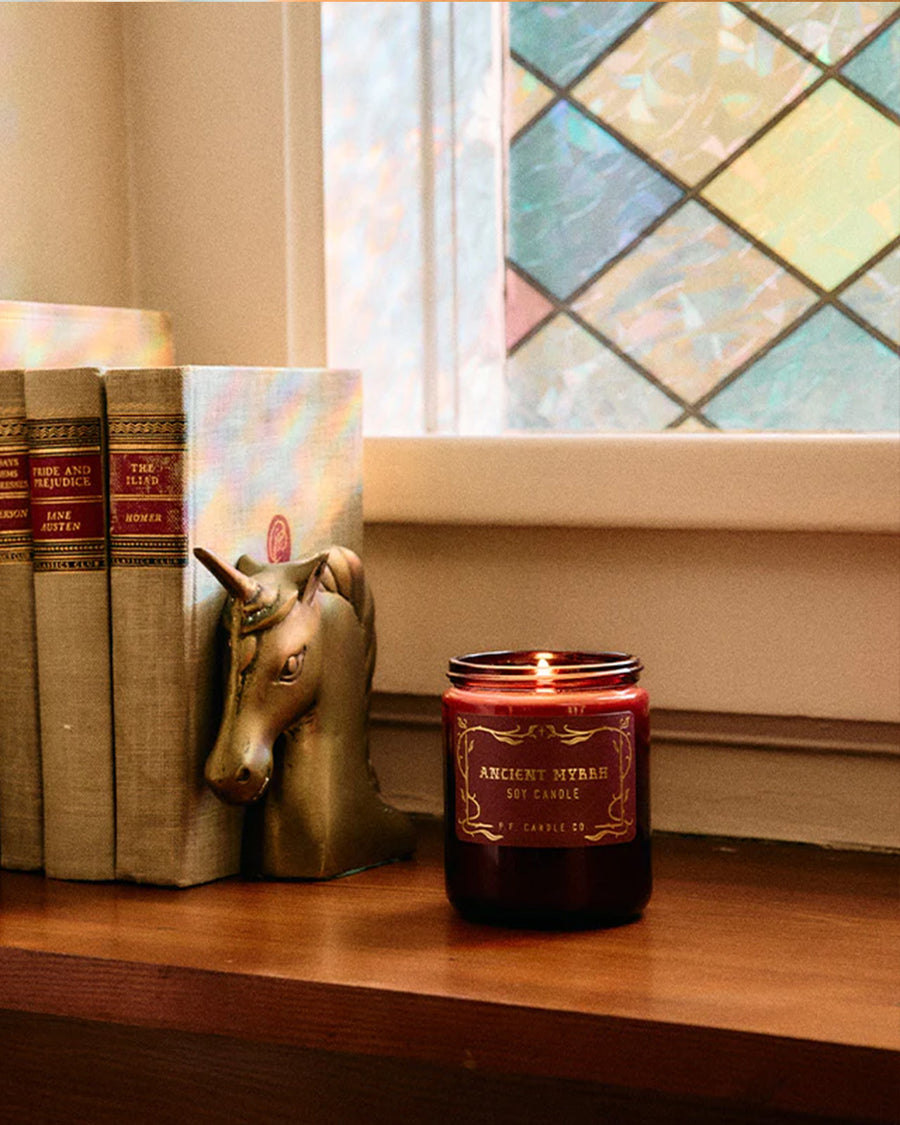 ancient myrrh standard candle with ed jar and gold lid on a table