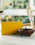 golden hour scented incense cone burning in small dish
