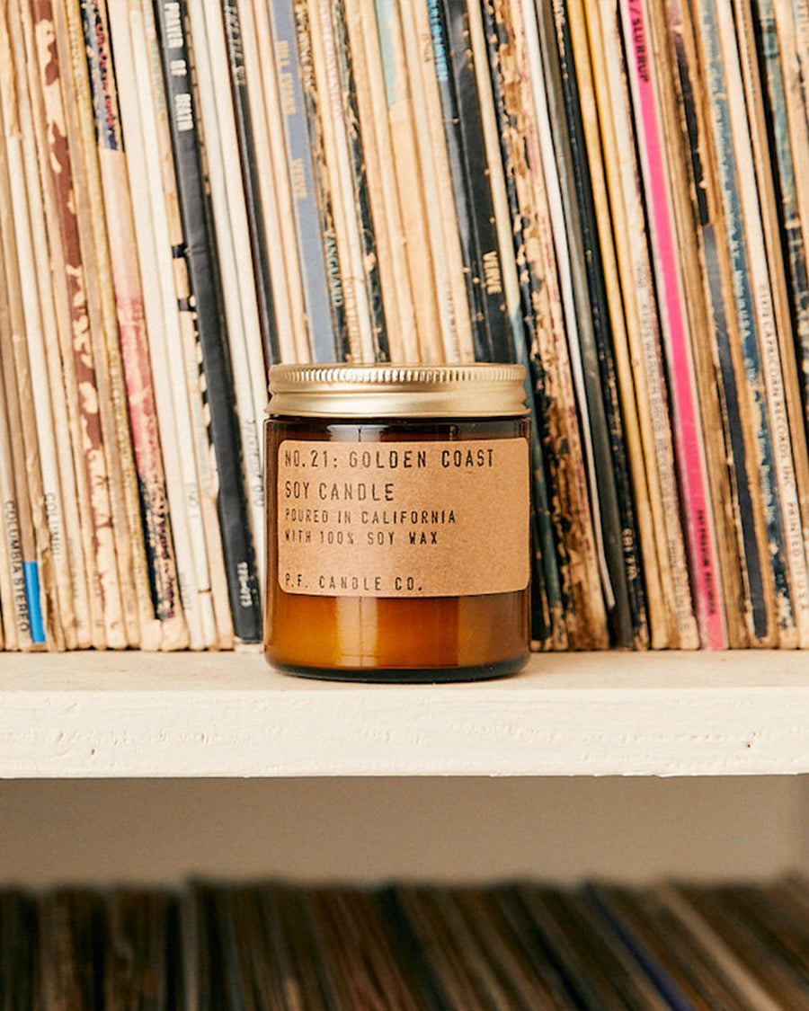 mini golden coast soy candle on book shelf