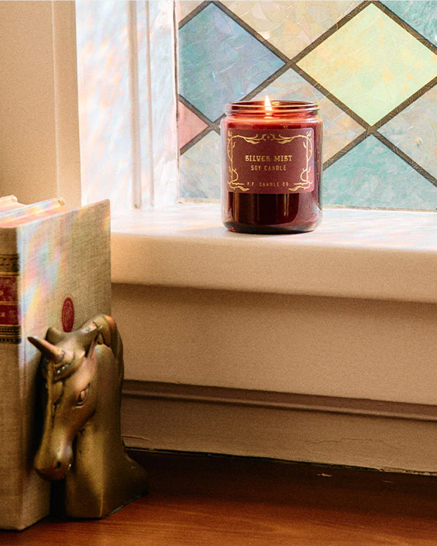 silver mist standard candle with ed jar and gold lid on a ledge
