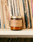 mini amber and moss scented soy candle on book shelf