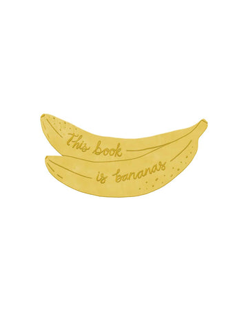 gold brass banana bookmark that has engraved 'this book is bananas'
