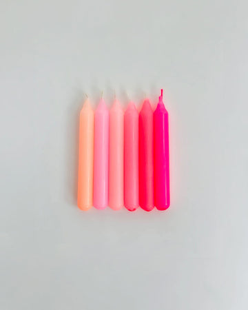 set of six small candles in various shades of pink