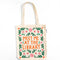 tan canvas bag with orange 'meet me at the library' surrounded by colorful flowers