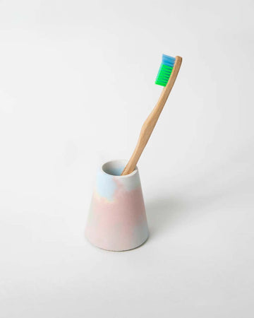 pastel rainbow concrete toothbrush holder with toothbrush inside