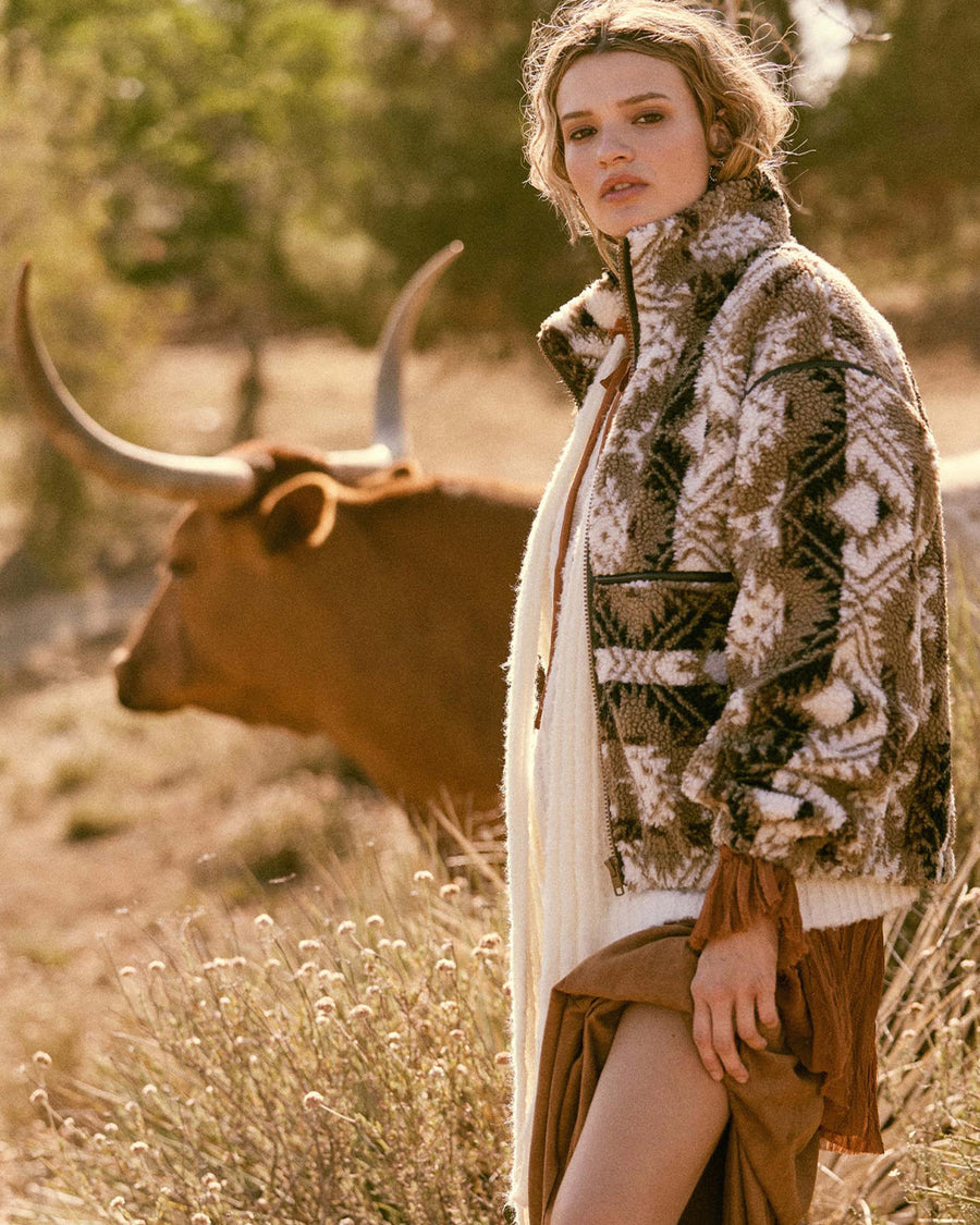 model wearing brown and white geometric zip up sherpa sweatshirt with faux leather trim