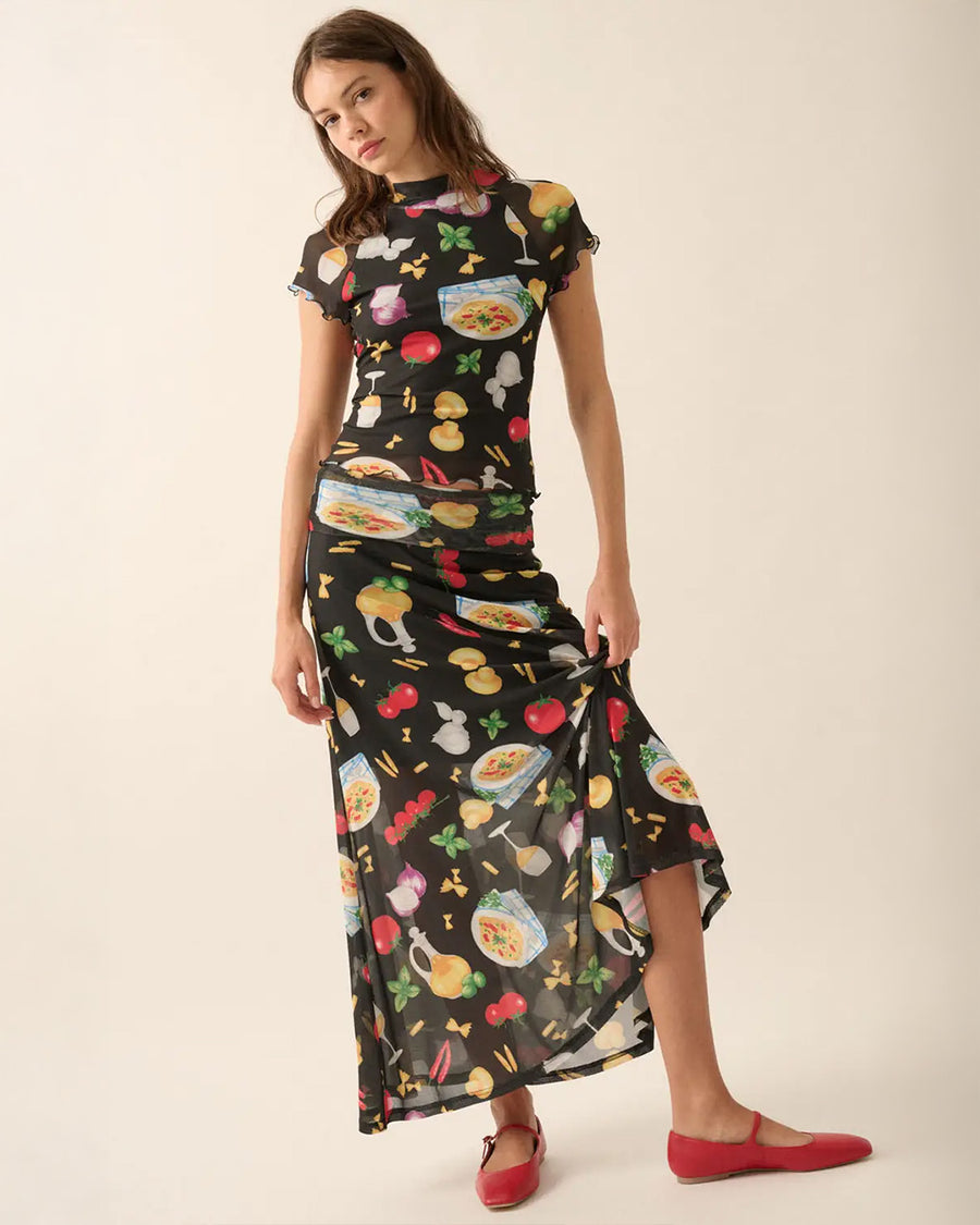 model wearing black fitted mesh top with ruffle sleeves and all over pasta and veggie print and matching skirt