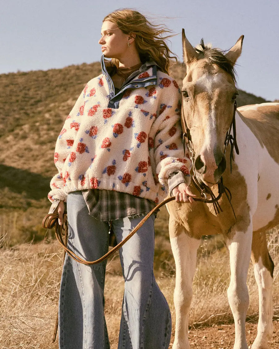 model wearing white sherpa half zip with denim trim and collar and red floral print