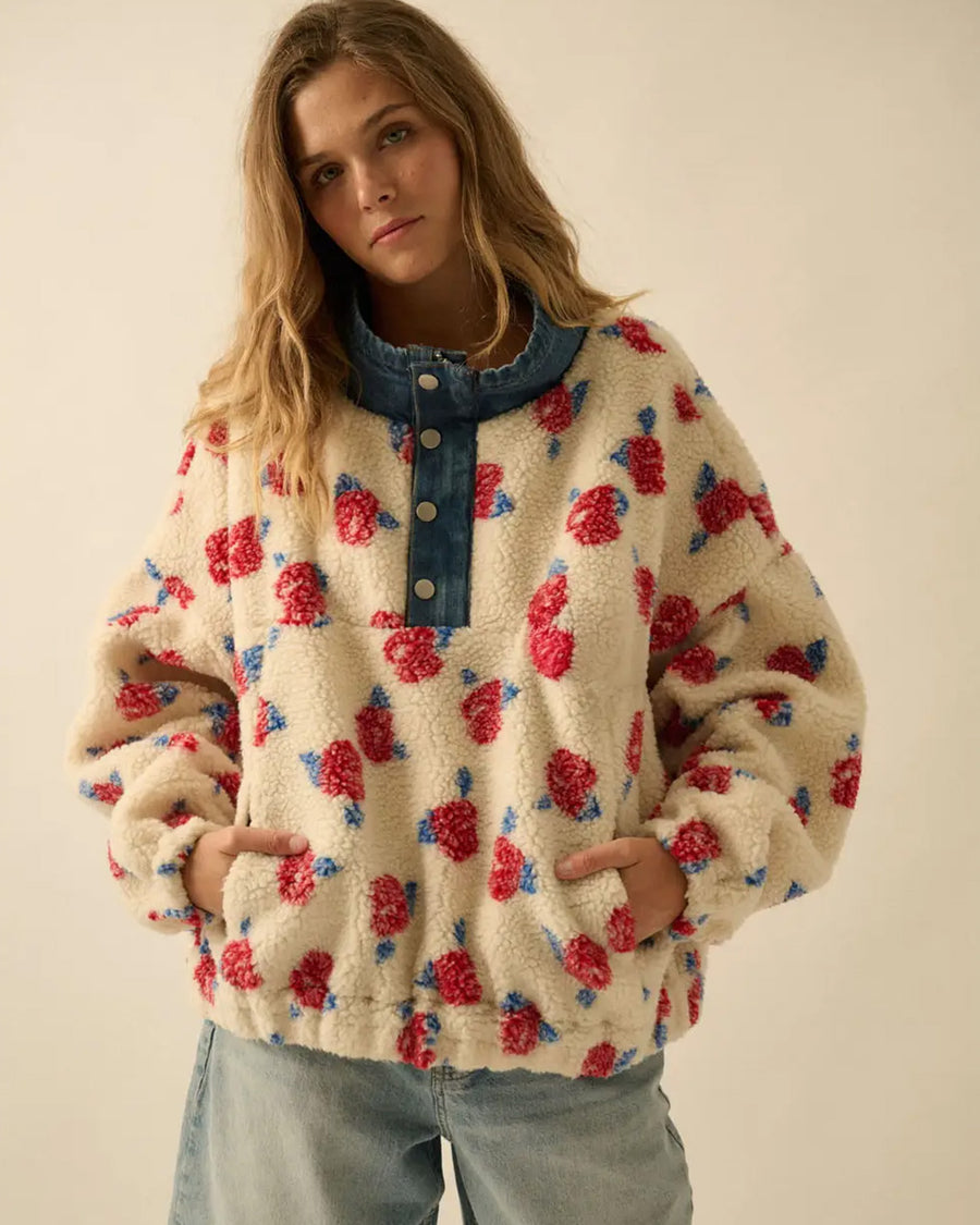 model wearing white sherpa half zip with denim trim and collar and red floral print