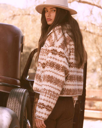 back view of model wearing cropped white zip up jacket with brown alpine print