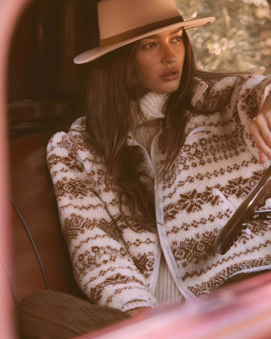 model wearing cropped white zip up jacket with brown alpine print