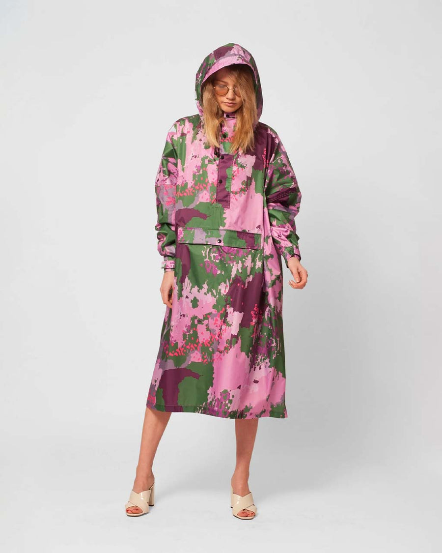 model wearing green, pink and purple digi glitch rain poncho
