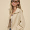 side view of model wearing light khaki cropped jacket with stand up collar and elastic bottom