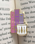 pink and purple geometric books and white mug pin inside book