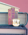 pink and purple geometric books and white mug pin