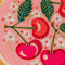 up close of pink embroidery kit with all over cherry and white flowers