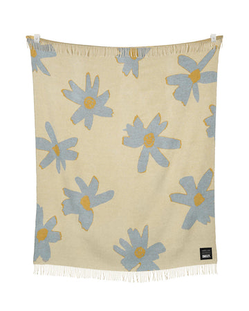 cream throw blanket with periwinkle flower print with smiley faces in the center
