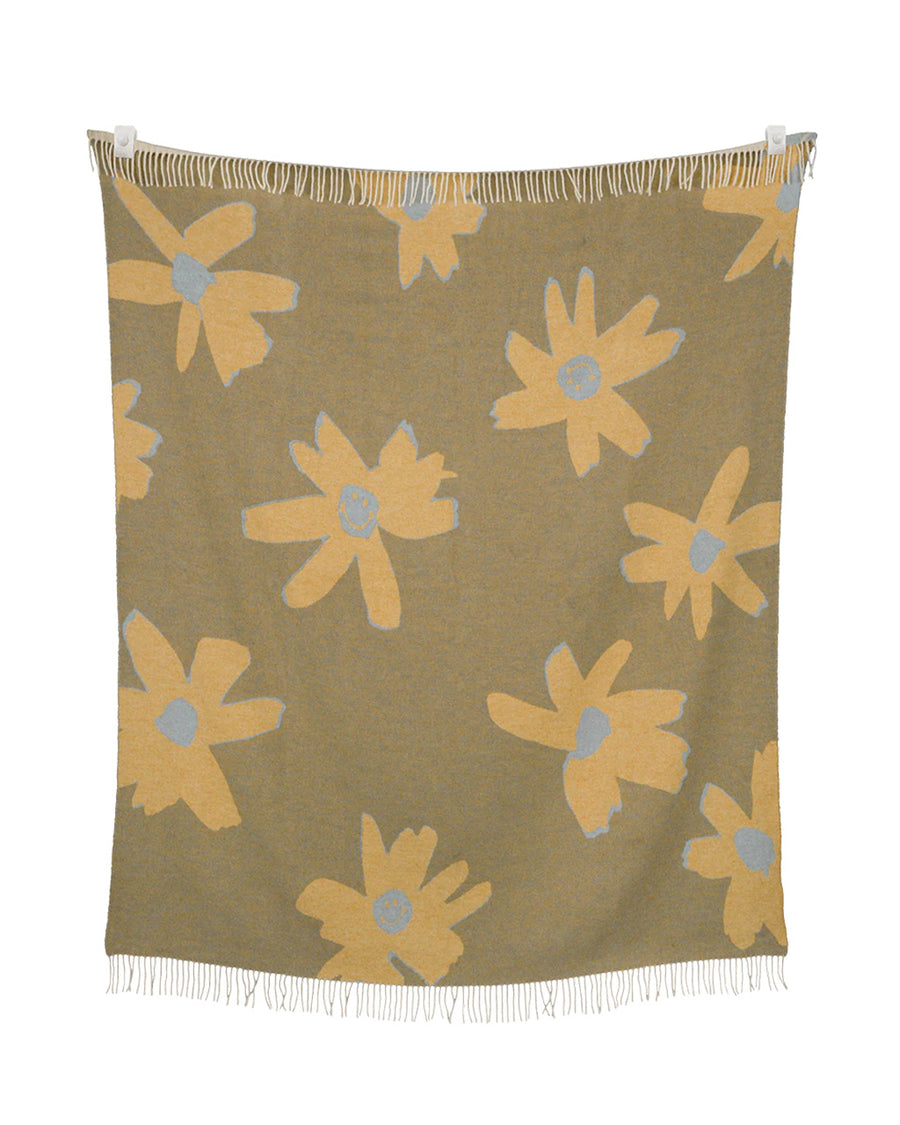 reversible side of brown throw blanket with gold flower print with smiley faces in the center