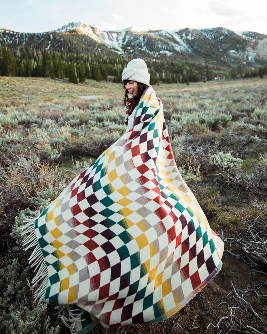 model wearing colorful trippy checkered throw blanket