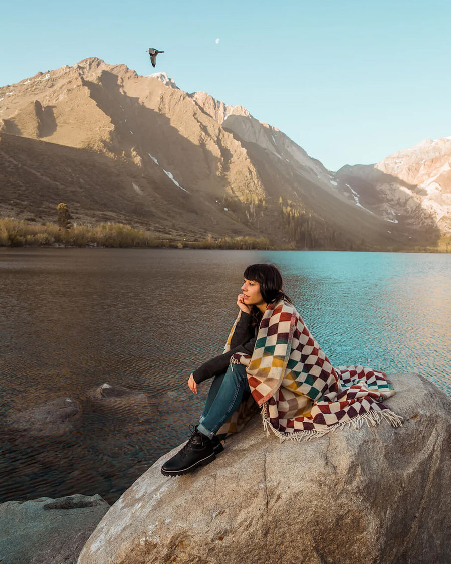 model wearing colorful trippy checkered throw blanket 