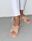 model wearing cream, brown and tan woven criss-cross sandals