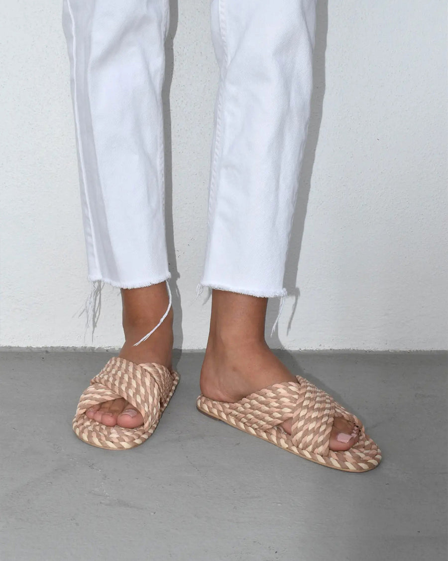 side view of model wearing cream, brown and tan woven criss-cross sandals