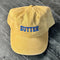 pastel yellow dad hat with blue 'BUTTER' across the front