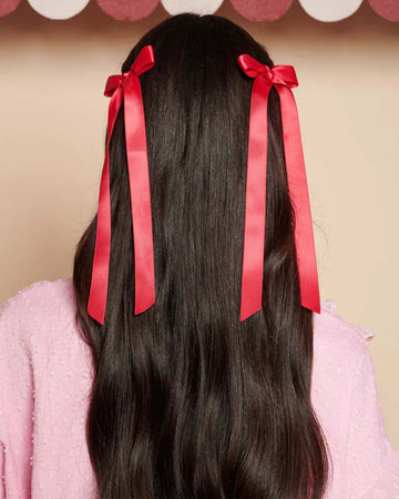 model wearing silky cranberry colored hair bows