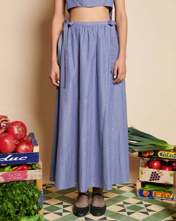 model wearing blue stripe midi skirt with bows at the waist and all over embellishments