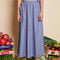 model wearing blue stripe midi skirt with bows at the waist and all over embellishments