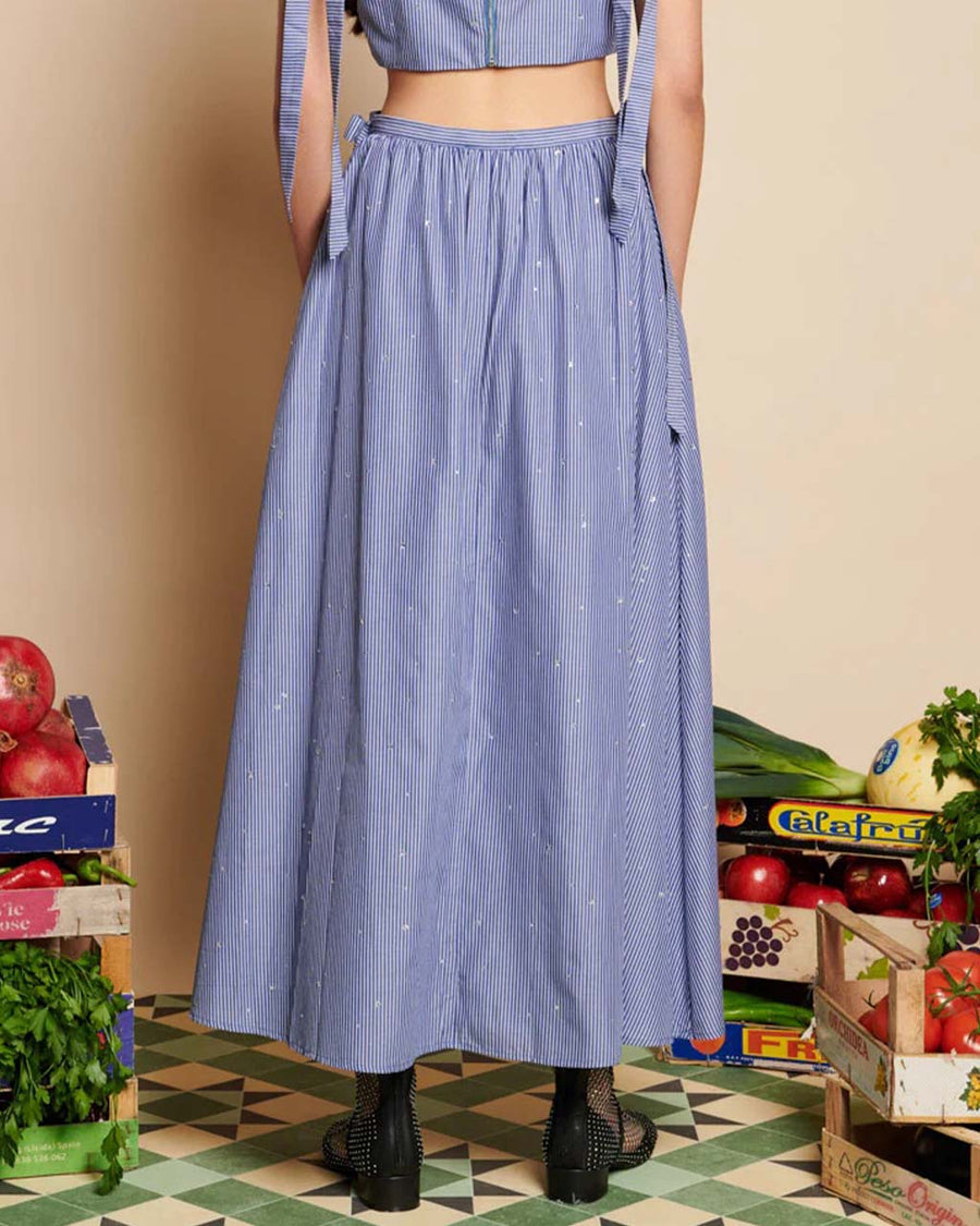 back view of model wearing blue stripe midi skirt with bows at the waist and all over embellishments