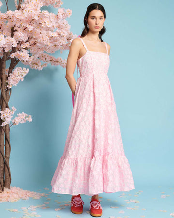 model wearing pink applique midi dress with ribbon bow straps
