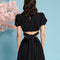 back view of model wearing black jacquard crop top with slight puff short sleeves and tie back