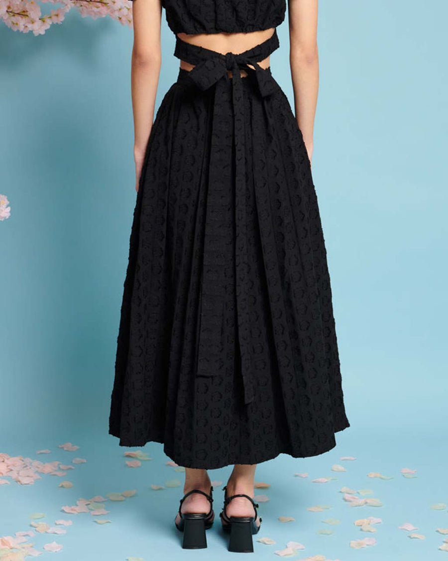 back view of model wearing black jacquard button front midi skirt