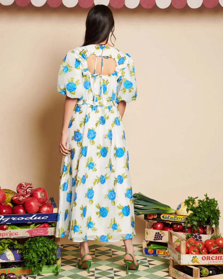 back view of model wearing white jacquard midi dress with all over blue floral print