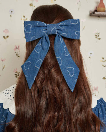 model wearing blue bow with heart design