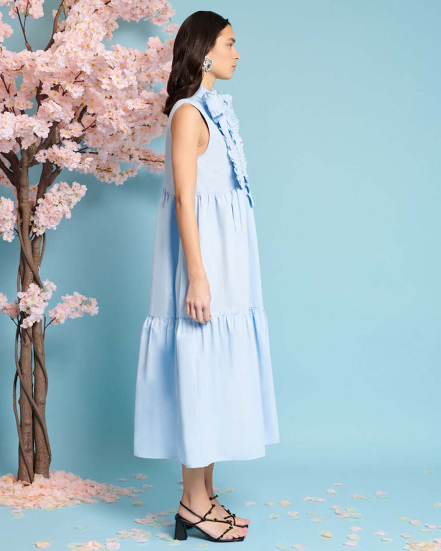 side view of model wearing baby blue tiered midi dress with exaggerated bow neckline