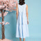 back view of model wearing baby blue tiered midi dress with exaggerated bow neckline
