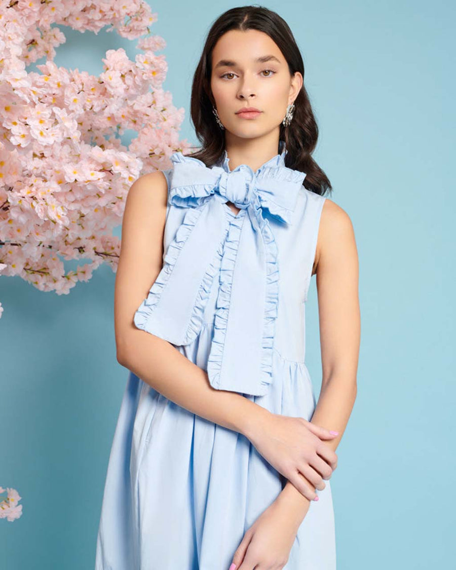 up close of model wearing baby blue tiered midi dress with exaggerated bow neckline