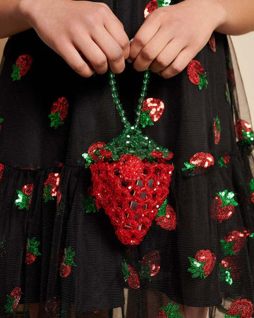 model holding beaded strawberry shaped mini bag