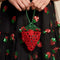 model holding beaded strawberry shaped mini bag