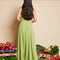 back view of model wearing green dress with subtle shine, ruffle trim and halter neckline
