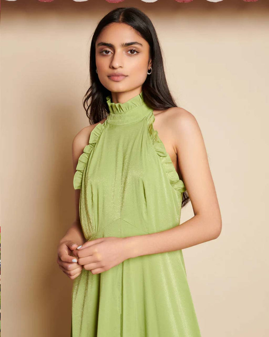 up close of model wearing green dress with subtle shine, ruffle trim and halter neckline