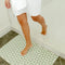 model stepping on mint green and cream checkered flower bath mat