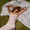model laying on cream and sky blue abstract palm tree and sun design turkish towel
