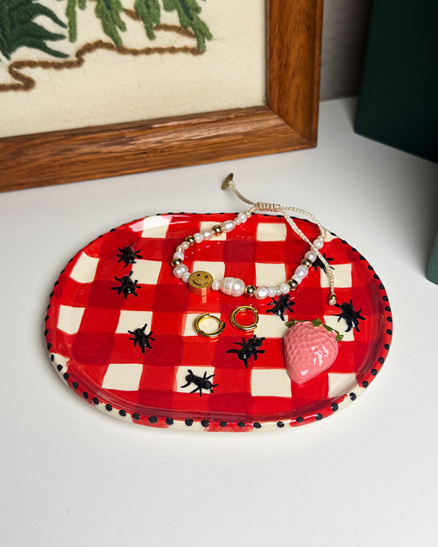 handmade tray with red and white gingham with 3d ant and strawberry print with jewelry on it