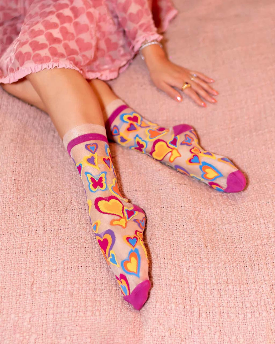model wearing sheer socks with colorful y2k heart print