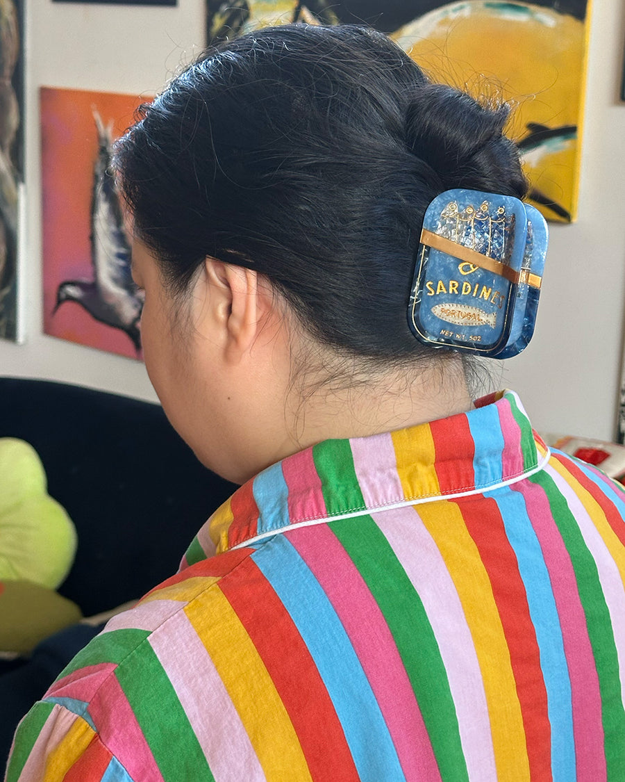 model wearing blue sardine can hair claw